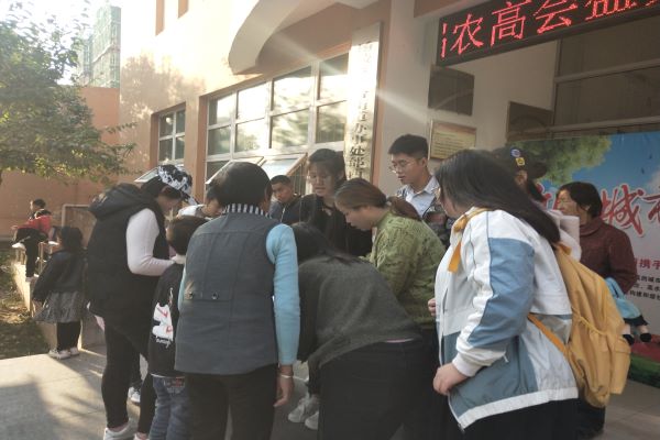 3833e6debe324e07a7d9469db1643cd1.jpg 志愿者正在通过宣传手册科普新冠肺炎知识.jpg